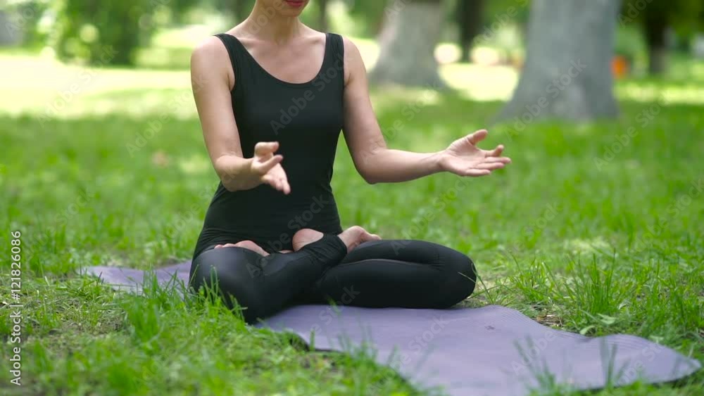 Woman meditating in lotus pose in the park. Woman meditating in lotus pose in the park.
