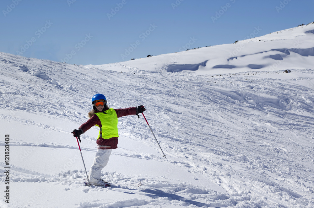 Little skier on ski slope with new fallen snow at sun day