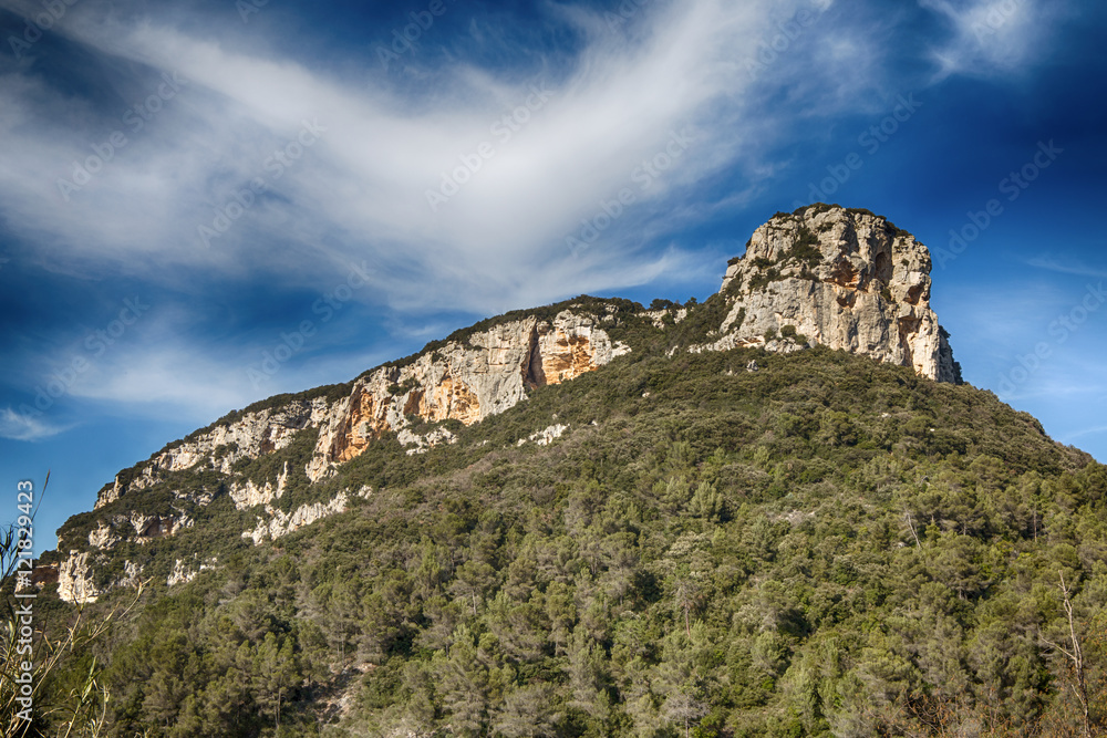 Isolated mountain inside green forest with bright blue sky / Monte Corno Finale Ligure Savona Liguria Italy