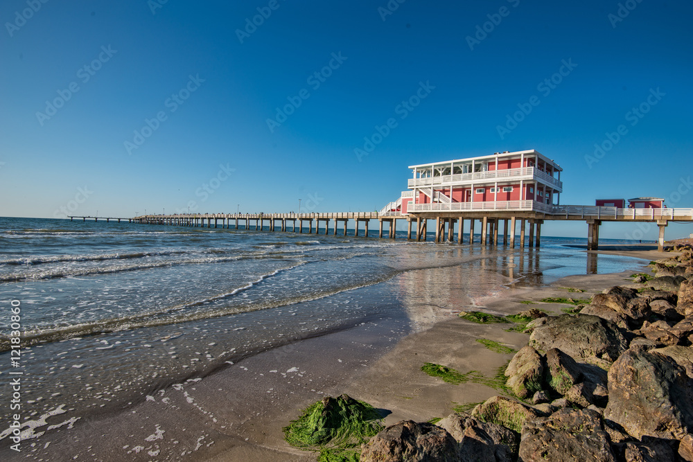 Reflections on Galveston Beach with fishing pier