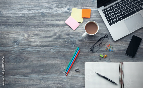 Laptop and notebook on wooden desk