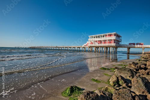 Reflections on Galveston Beach with fishing pier