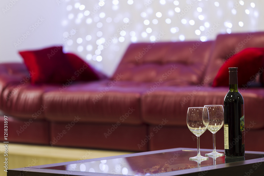 Interior with a coffee table, a sofa and a bottle of wine Interior with a coffee table, a sofa and a bottle of wine