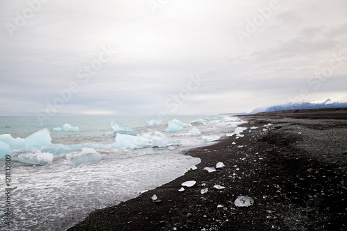 Beautiful beach in South Iceland with black lava sand and iceber photo