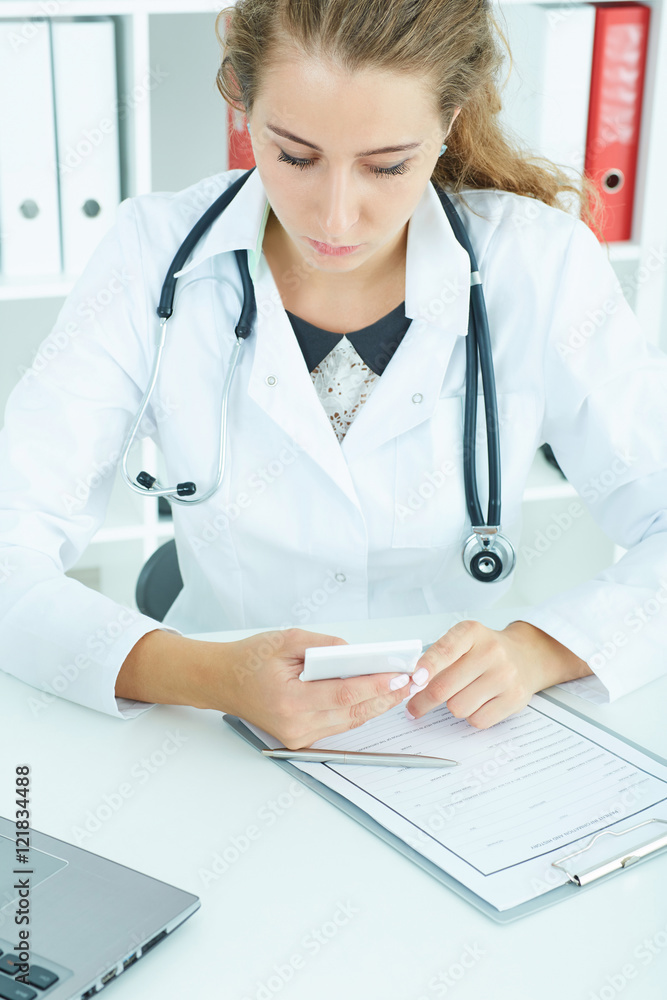 Portrait of a beautiful medical doctor texting on the phone. Portrait of a beautiful medical doctor texting on the phone.