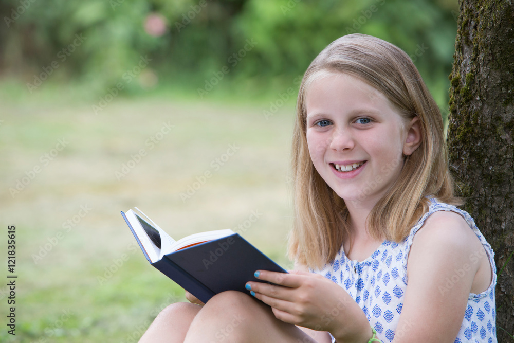 Girl Sitting Against Tree In Garden Reading Book Girl Sitting Against Tree In Garden Reading Book