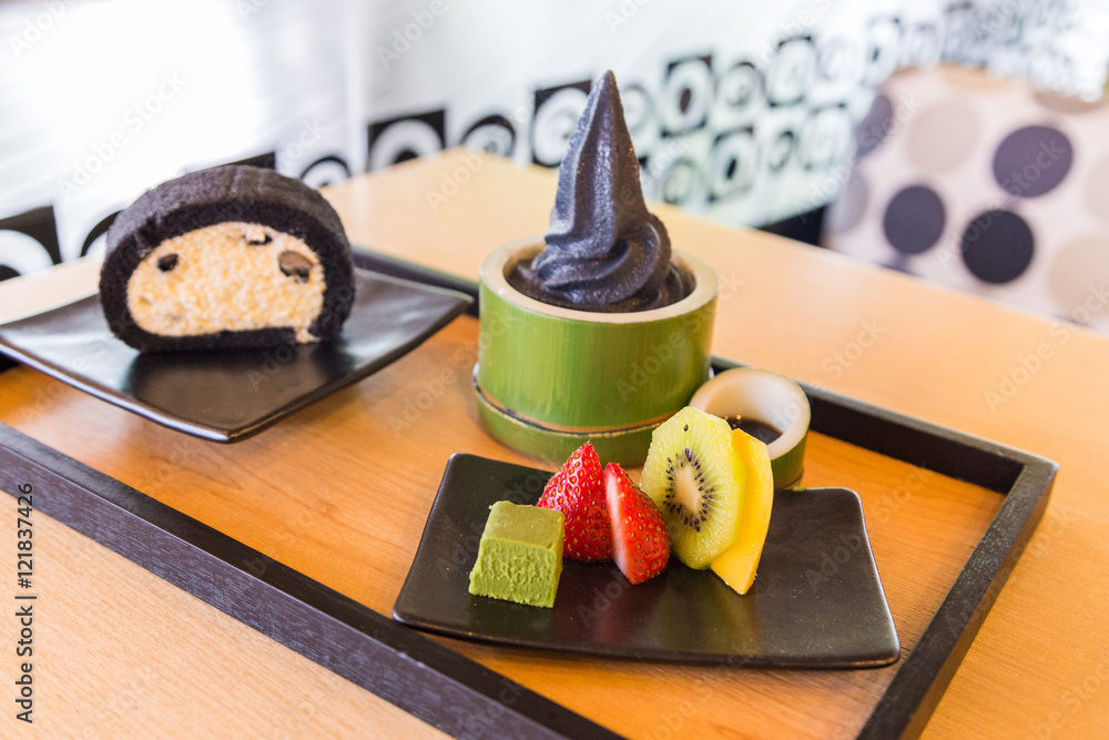 Charcoal vanilla soft cream with roll cake and fruit platter.