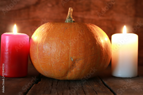 pumpkin and candle on old wooden