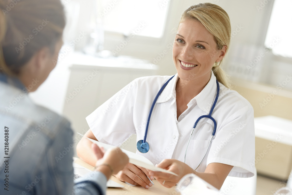 Portrait of doctor giving prescription to patient