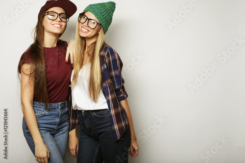  Two young girl friends standing together and having fun