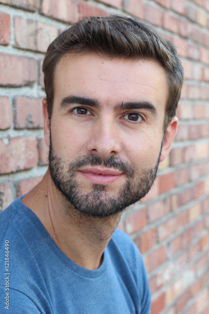 Portrait of a handsome young guy against the backdrop of a red brick wall Portrait of a handsome young guy against the backdrop of a red brick wall