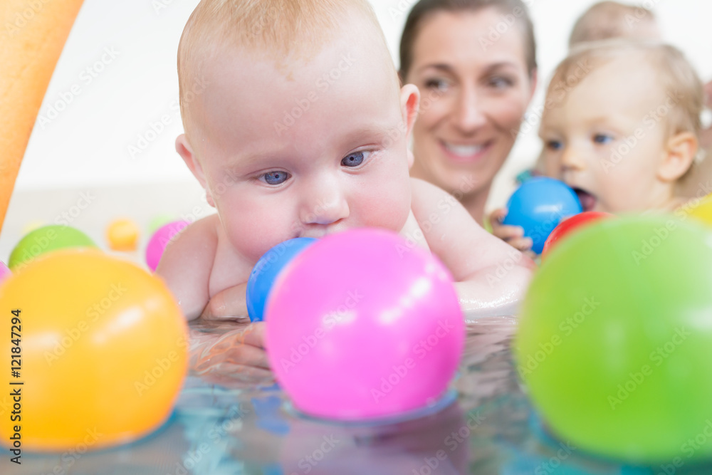 Obraz premium Mums and babies having fun at infant swimming course