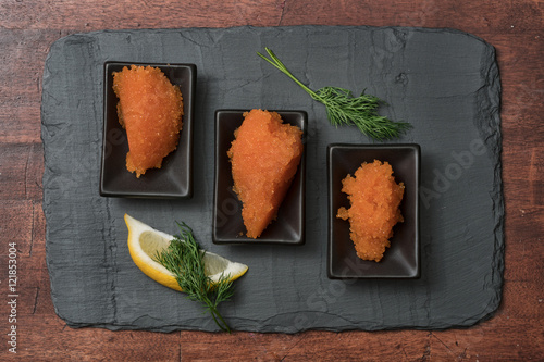 Appetizing starter with Swedish caviar served on a stone plate photo