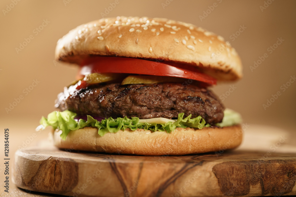 fresh homemade burger with marble beef, cheese and vegetables on olive board fresh homemade burger with marble beef, cheese and vegetables on olive board