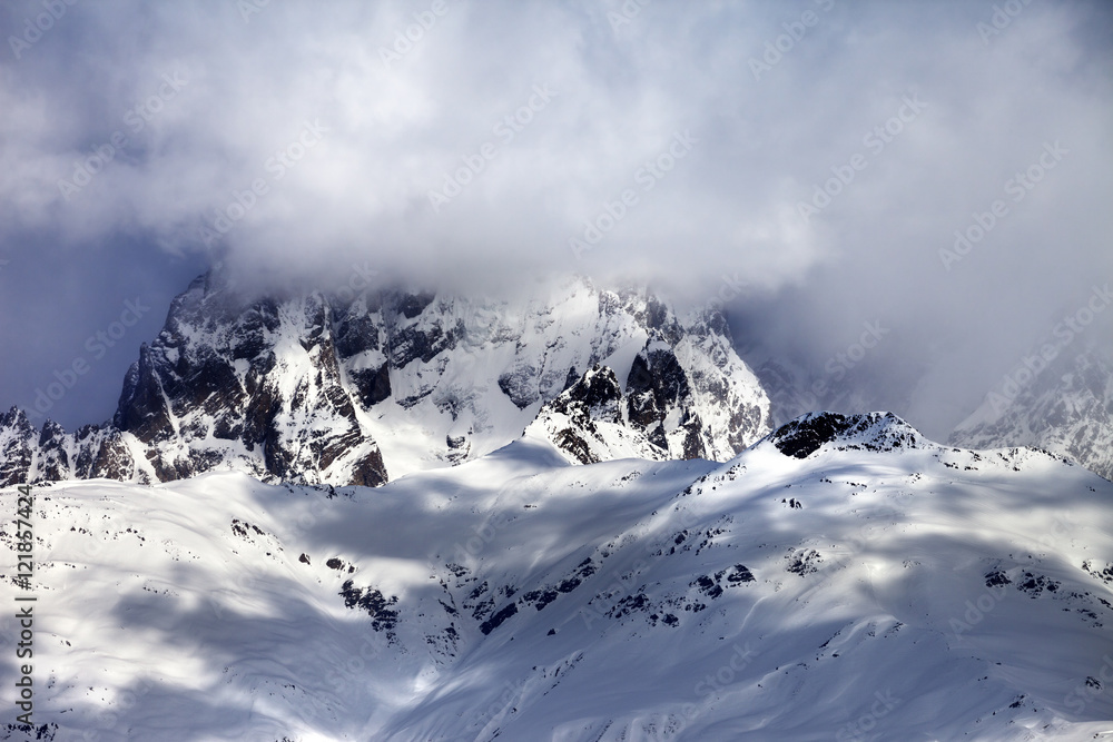 Mount Ushba in fog at sun winter day