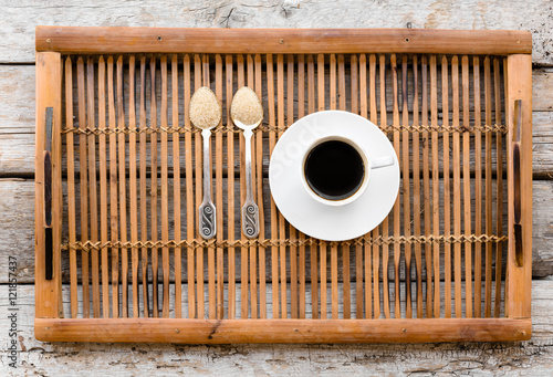 Cup of black coffee and two teaspoons of brown sugar. Concept of dieting and weighting lost. Concept of brain food for intellectual energetically work.