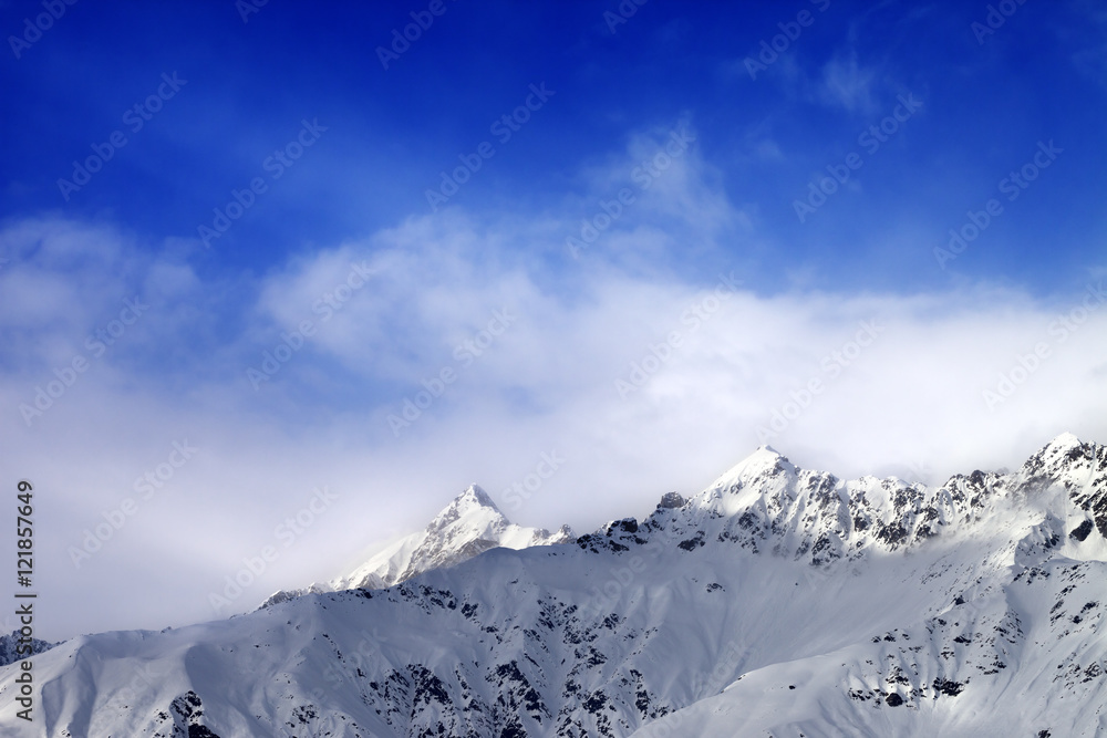 Snow sunlight mountain peak in fog and blue sky