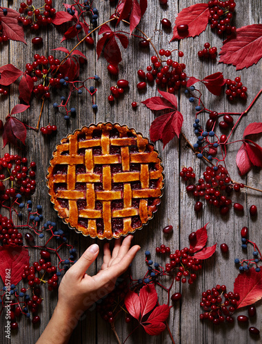 Traditional strawberry pie tart cake sweet baked pastry food on rustic wooden table background. Autumn creative composition decoration. Hands in the frame. photo