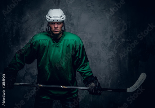 Canvas Print Hockey player in protective clothes holds playing stick.