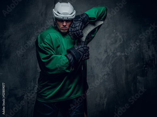Photography Hockey player in protective clothes holds playing stick.