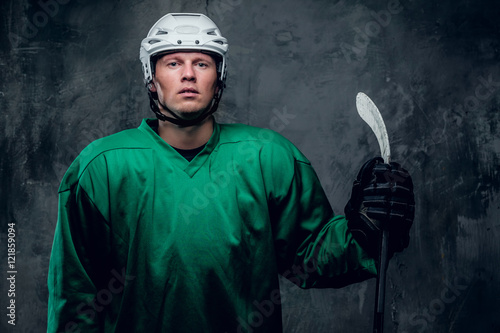 Photography Hockey player in protective clothes holds playing stick.