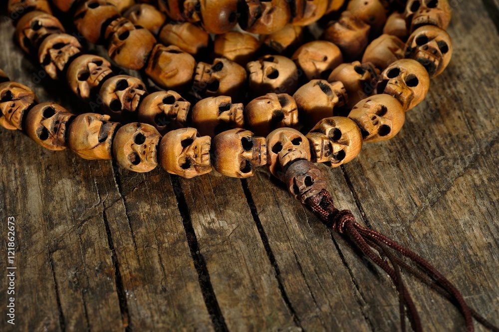 religious rosary of skulls of sandalwood on an old table, closeup
religious rosary of skulls of sandalwood on an old table, closeup