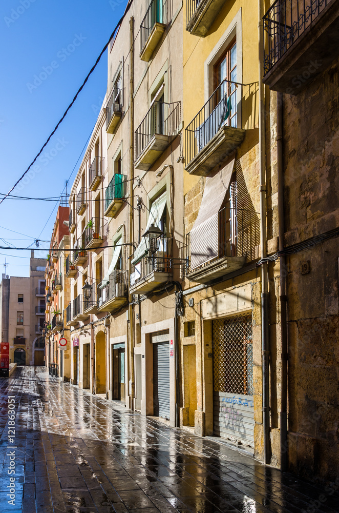 Wet sunny street early morning in Tarragona, Spain