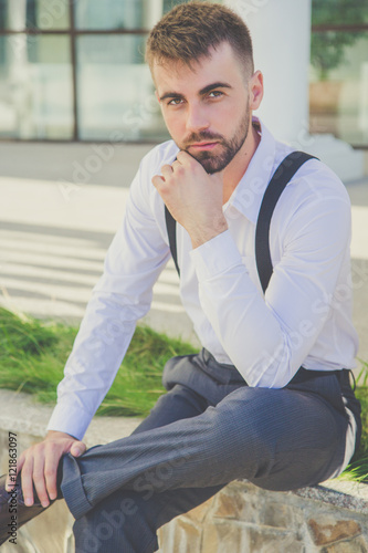 Stylish man with beard is wearing suspenders