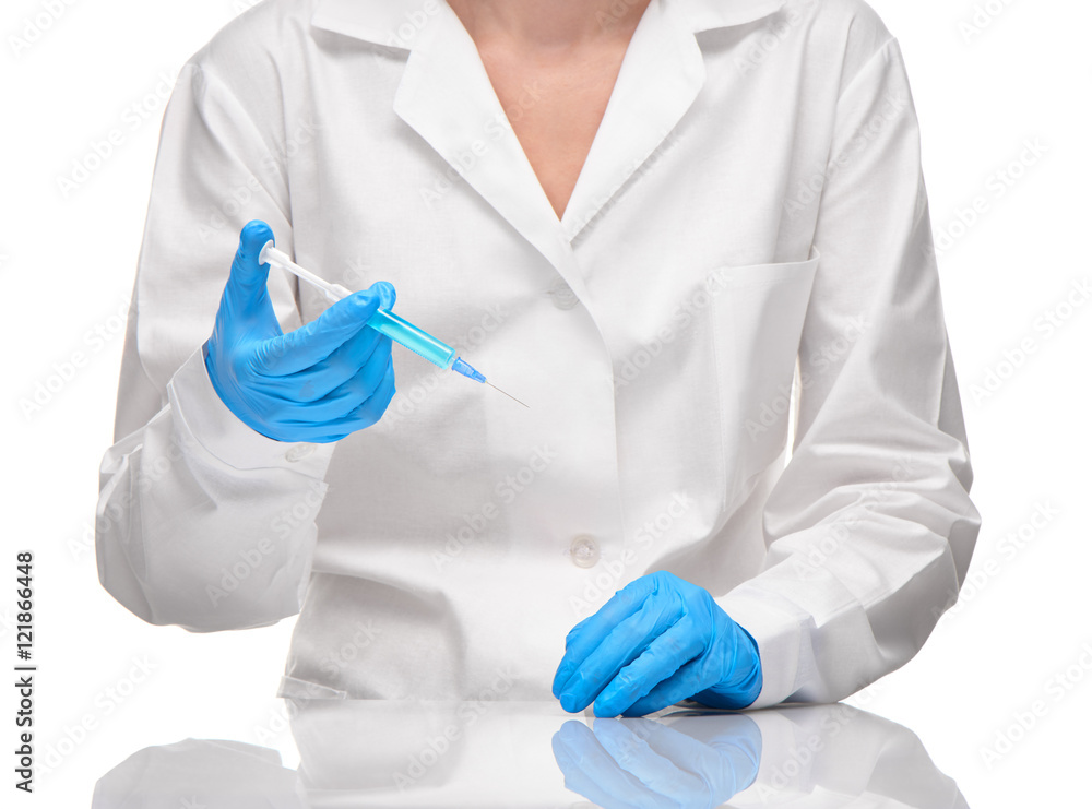 Doctor in gown and gloves holding syringe with blue drug