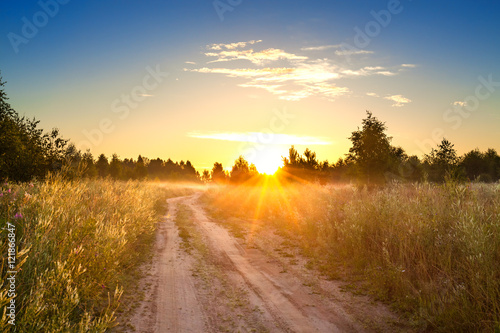 summer rural landscape with sunrise , fog and the road