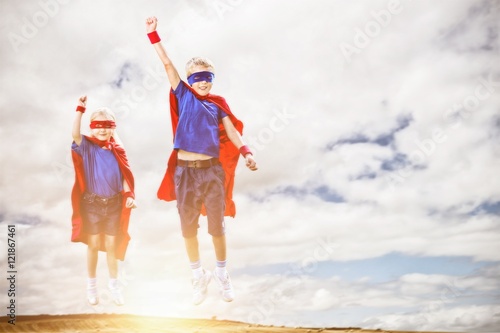 Composite image of brother and sister pretending to be superhero
