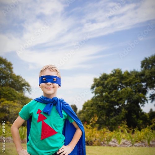 Composite image of portrait of boy in blue eye mask and cape