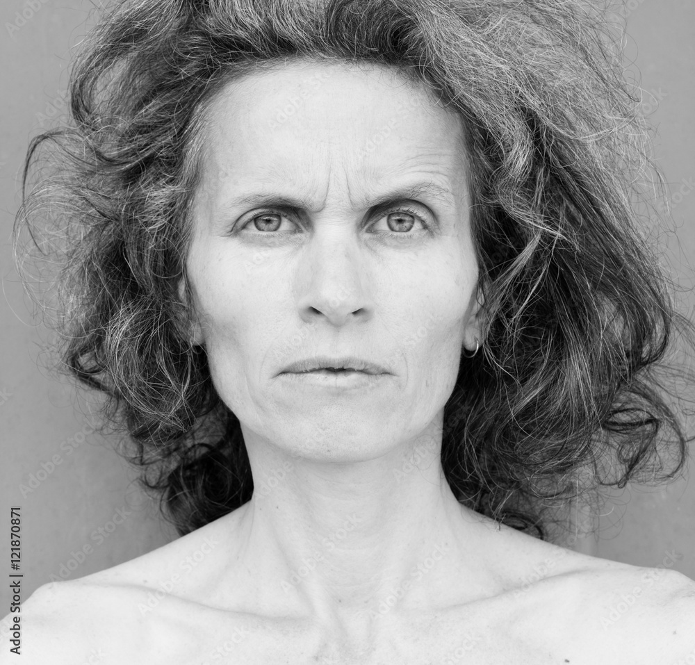 Head and shoulders portrait of frowning middle aged woman with grey hair (black and white) Head and shoulders portrait of frowning middle aged woman with grey hair (black and white)