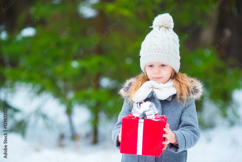 Adorable little girl with christmas box gift in winter day outdoors Adorable little girl with christmas box gift in winter day outdoors