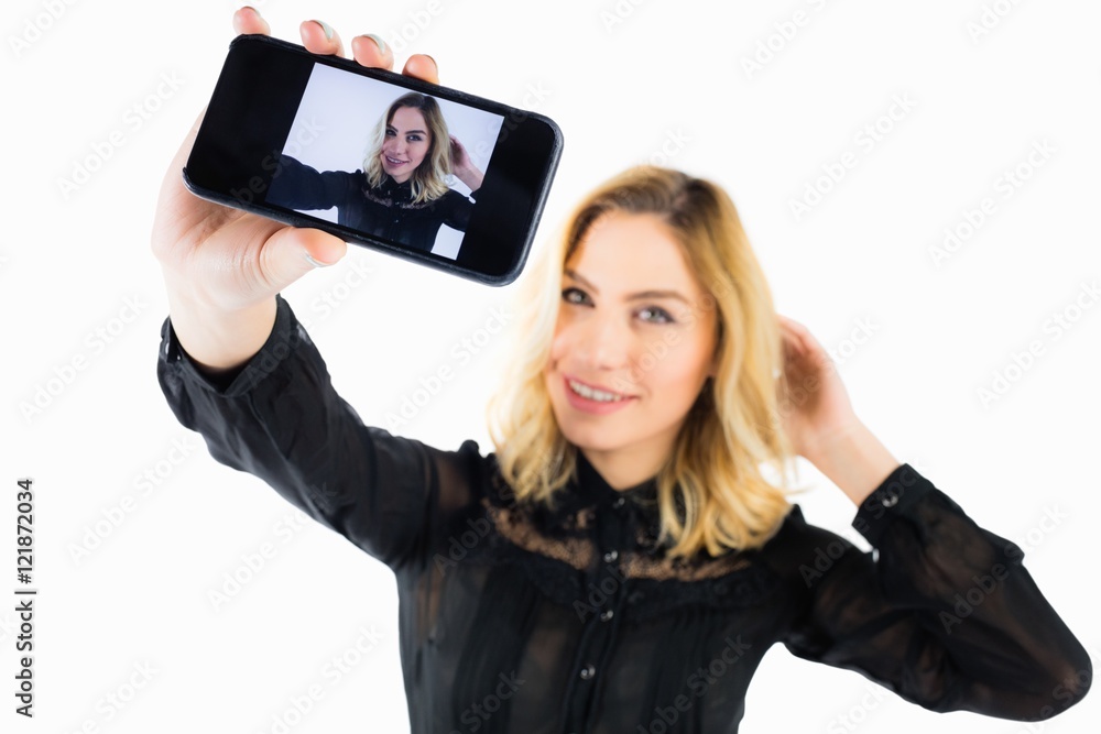 Smiling woman clicking photo from mobile phone Smiling woman clicking photo from mobile phone
