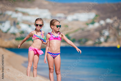 Adorable little girls having fun during beach vacation. Two kids together on greek vacation