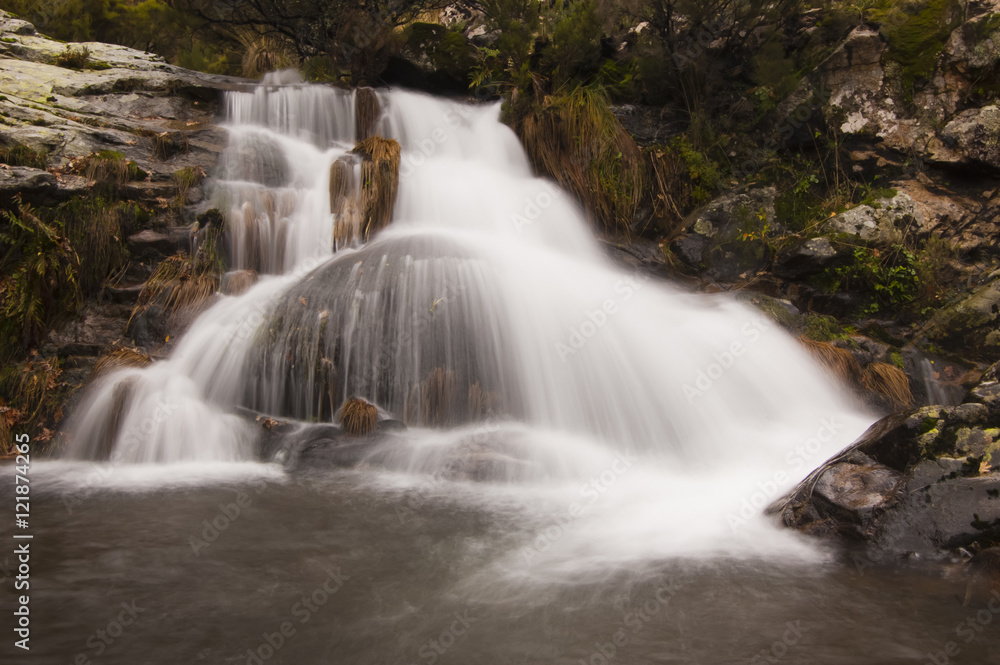 Cascada de agua sobre piedra redonda en otoño en el valle del Ambroz en Extremadura Cascada de agua sobre piedra redonda en otoño en el valle del Ambroz en Extremadura