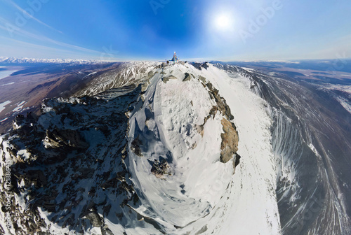 Aerial survey the top of a snowy mountain on a sunny day at the
