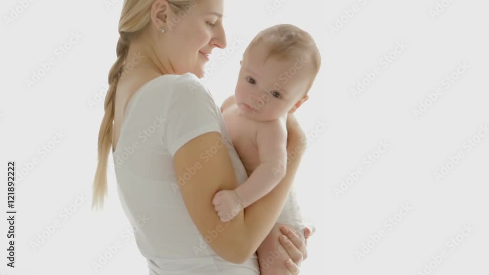 Happy young mother with her baby boy standing in front of big window. People on white isolated background Happy young mother with her baby boy standing in front of big window. People on white isolated background