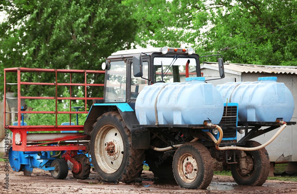 Obraz premium Tractor with tanks on the farmland