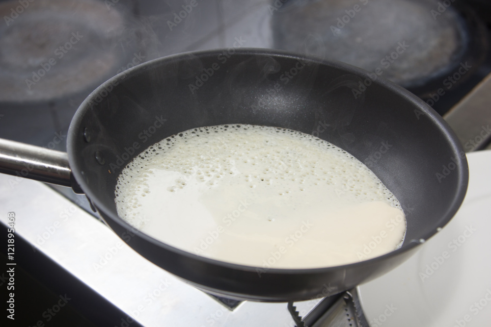 Cooking pancakes the cook pours the batter in the pan. Cooking pancakes the cook pours the batter in the pan.
