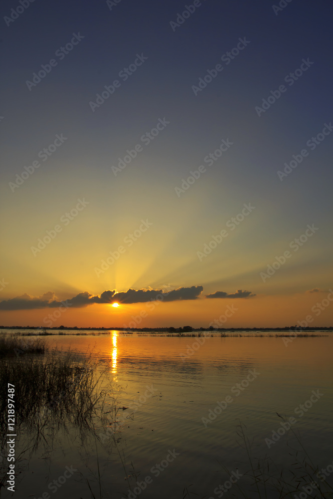 Sunset behind cloud sky with water field landscape