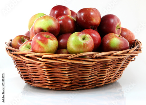Basket with red apples on white background