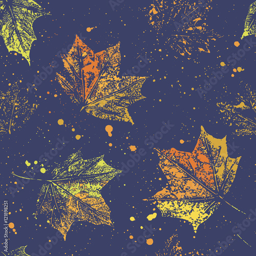 Seamless pattern of autumn maple leaves and splashes on dark blue background.  The pattern is suitable for decoration packaging paper and textiles.
