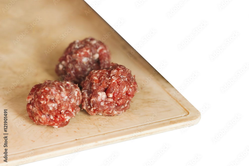 Raw meatballs on a wooden board. Isolated
