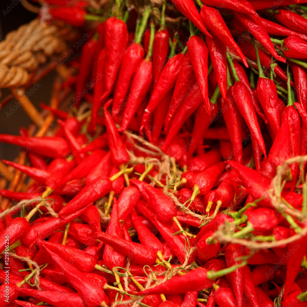 pile of small, red, very hot and spicy chilli peppers on an ital pile of small, red, very hot and spicy chilli peppers on an ital