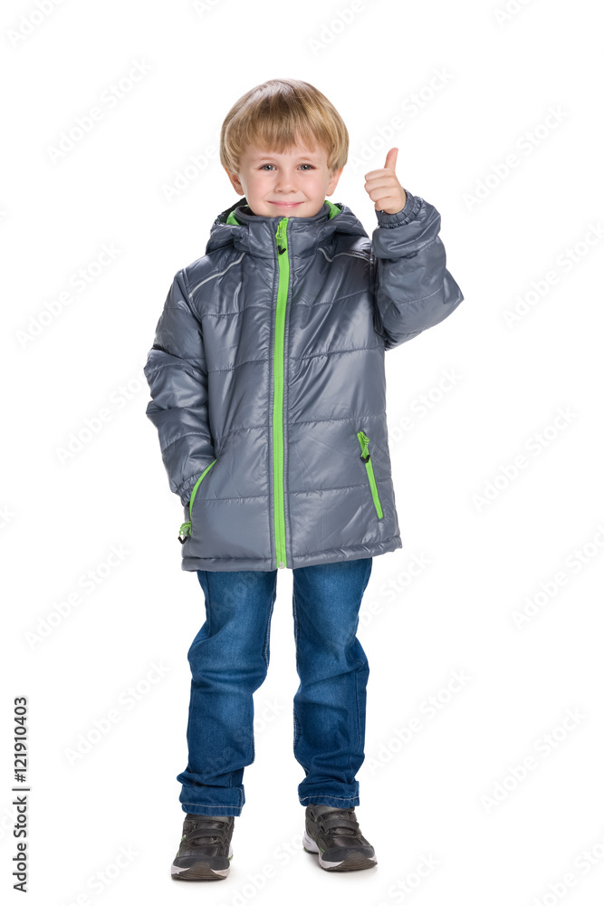 Little boy in a coat holds his thumb up Little boy in a coat holds his thumb up