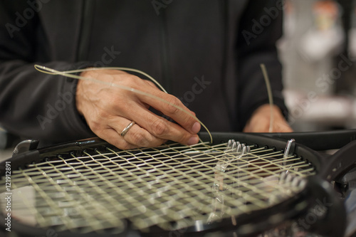 Stringing Machine. Close up of tennis stringer hands doing racket stringing in his workshop