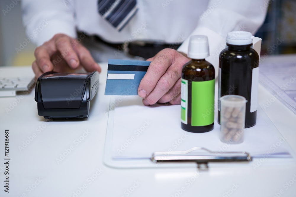 Pharmacist using payment terminal machine Pharmacist using payment terminal machine