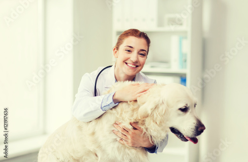 Fototapeta Naklejka Na Ścianę i Meble -  happy doctor with retriever dog at vet clinic